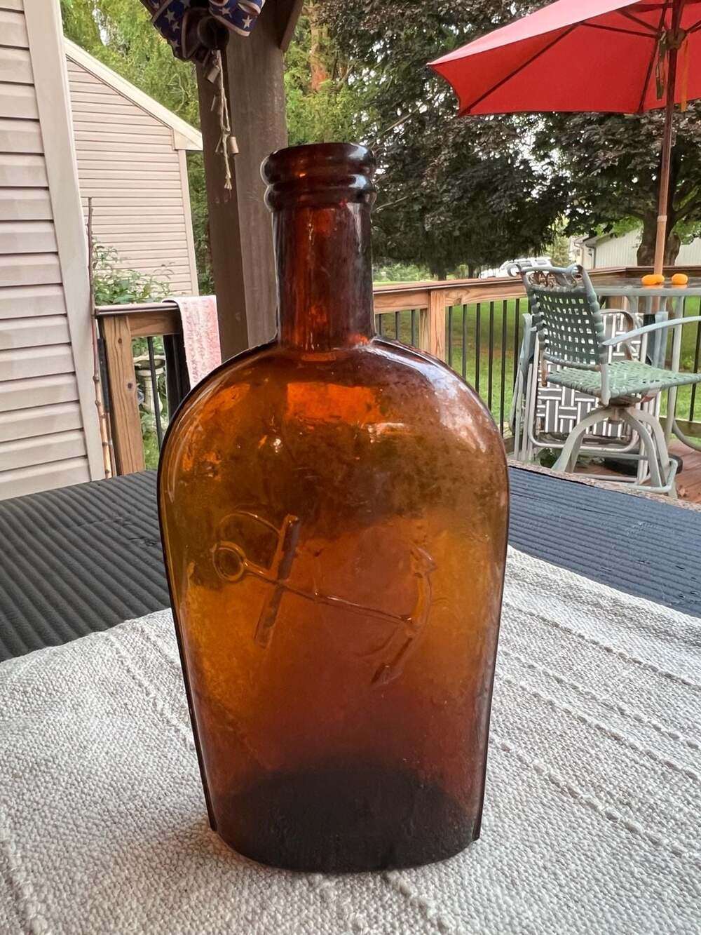 Antique Amber Glass Strap-Sided Whiskey Flask with Embossed Anchor